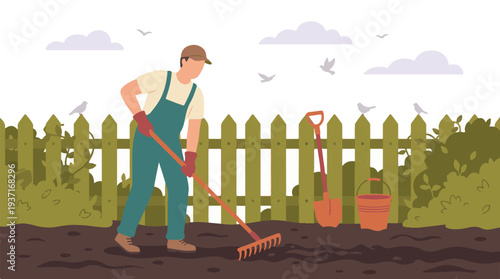 Man raking soil in a garden, preparing land for spring planting