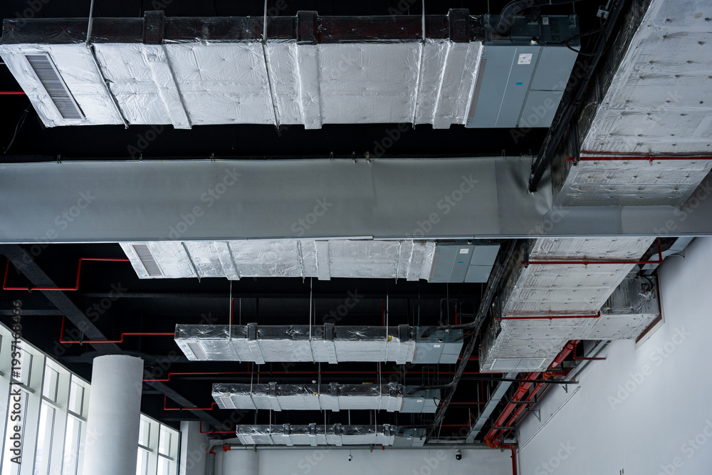 Fototapeta premium Exposed industrial ceiling with ventilation ducts metal framework and insulation layers