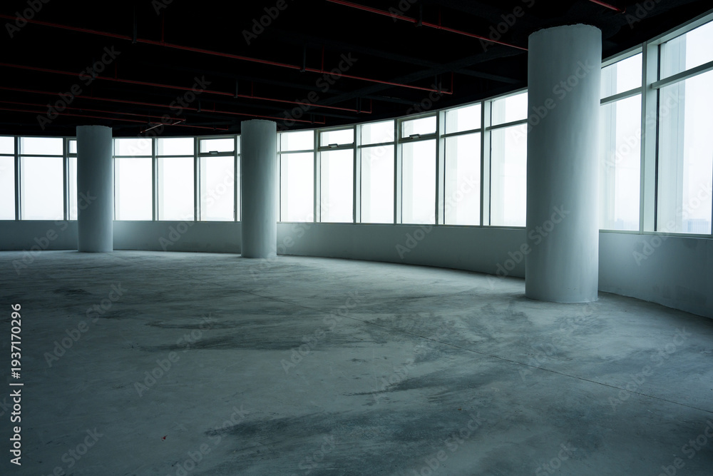 Naklejka premium Empty office building interior with concrete floor and structural columns