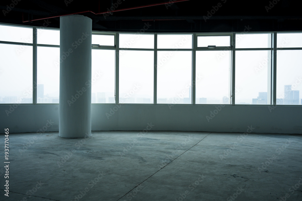 Fototapeta premium Empty modern office space with floor-to-ceiling windows overlooking city skyline