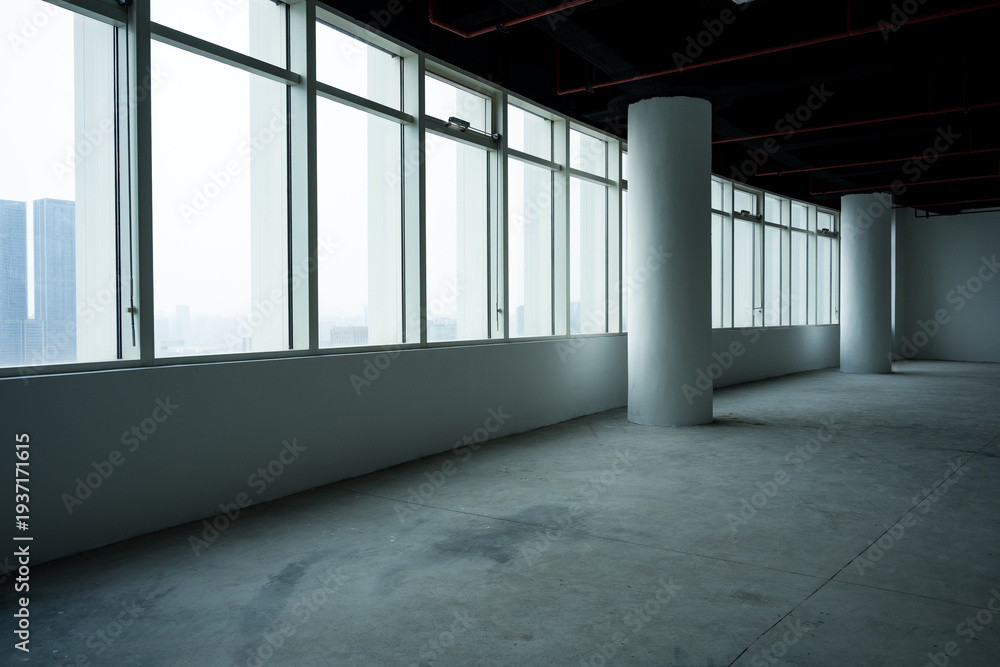 Fototapeta premium Empty modern office space with floor-to-ceiling windows and concrete columns