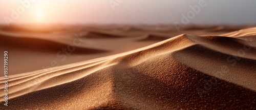 Waves of golden sand beneath a glowing sunset sky