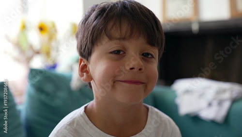 Photos Young boy smirking playfully at camera, confident expression, cheeky smile, chil