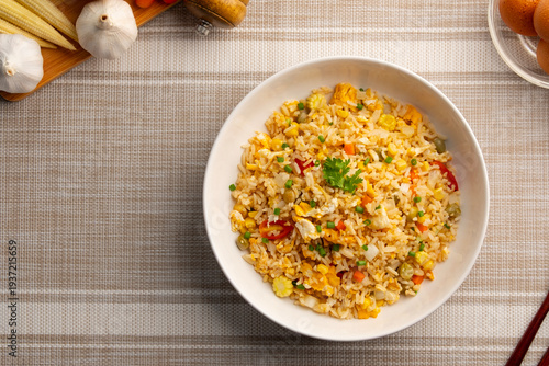 Thai Fried rice with egg ,green pea ,carrot ,corn and tomato in white plate.Top view.