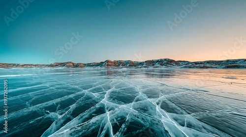 Frozen Lake with Intricate Ice Patterns and Mountain Range at Dawn