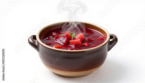 Delicious beetroot soup in a small pot with steam and fresh herbs