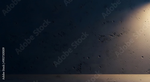Grungy dark concrete wall texture with dramatic spotlight illumination on right side showing rough surface details and crater like imperfections now