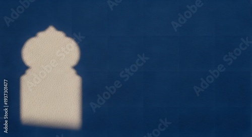 Minimalist blue wall with elegant arabic arch shadow light effect creating serene architectural atmosphere for ramadan and islamic culture themes