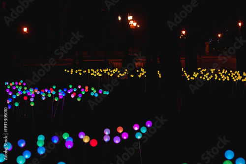 Colorful lights create a bright scene in a park at night during a festive event showcasing community creativity and spirit