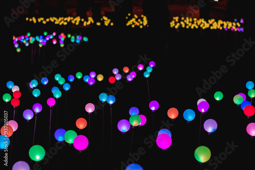 Colorful lights create a bright scene in a park at night during a festive event showcasing community creativity and spirit