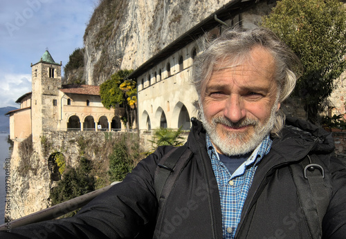 Mature Man portrait in front of the St. Caterina hermitage , Italy