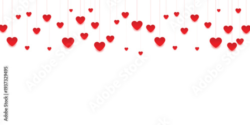 Multiple red hearts hanging from strings on for valentines day