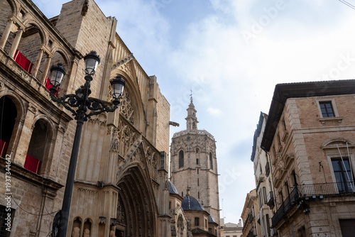 Valencia Cathedral and Miguelete Tower (Micalet) from Plaza de la Reina, Spain. A Gothic masterpiece standing tall, framed by the lively ambiance of one of Valencia’s most iconic squares.