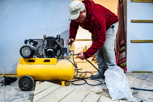 Man starting the air compressor with your hand in garage.