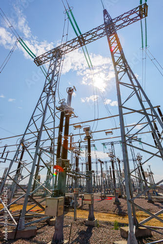 Vertical view of an outdoor electrical distribution substation, without people, at daytime on a background of a clear blue sky