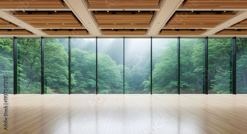 Expansive modern room with floor to ceiling windows showcasing a lush green misty forest landscape and wooden ceiling