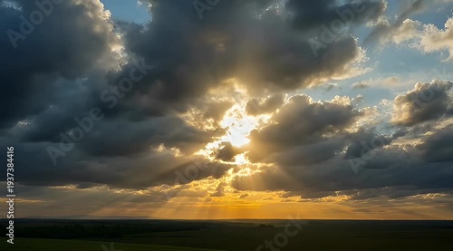 Dramatic golden sunset sky with sun rays beaming through billowing clouds