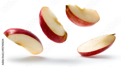Four vibrant red apple slices captured mid-air against a clean white background.