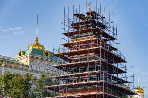 Canvas Print Moscow Kremlin tower under restoration with scaffolding protecting historic arch