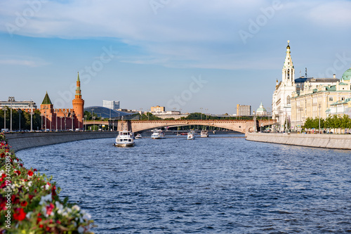 Moscow Kremlin towers and Moskva River with tour boats on a sunny day