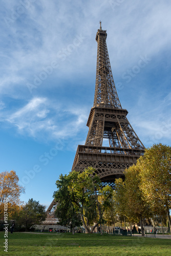 Walking in Paris in autumn, view on part trees and iconic Eiffel tower in daytime