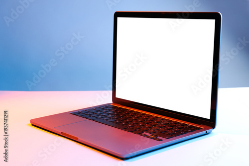 Modern laptop with blank screen in neon lights on white table