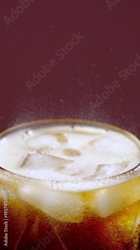 Closeup of chilled soda and icy sparkle. Photograph showcasing bubbly soda pouring over ice with vibrant backdrop and refreshing summer feel