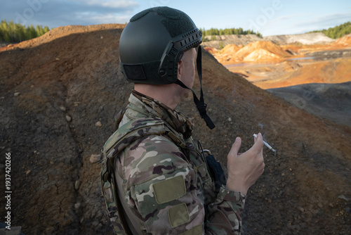 Armed Soldier in Military Uniform Smoking While Observing Quarry Landscape