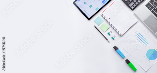 A business desk with documents, a tablet, pens, and a laptop. A professional flat lay ideal for data analysis, reports, and corporate work.