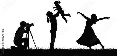 Black silhouette of a photographer taking pictures of a mother lifting her child and a woman dancing in a grassy field.