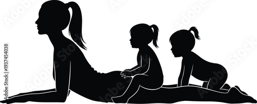 Black silhouette of a young mother practicing a stretching yoga pose while her two playful children sit and crawl on her back.