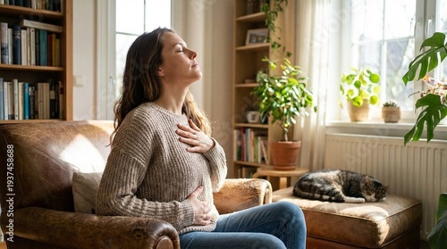 White adult woman practicing mindful breathing on living room sofa, calm wellness and self care at home, cozy daylight interior with houseplants and cat, Mental Health Awareness