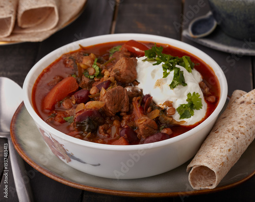 Moroccan lamb stew garnished with yogurt and herbs.