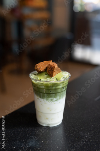 Iced matcha latte layered with milk and topped with crunchy brown sugar waffle pieces