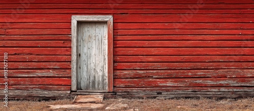 Rustic weathered wooden door on the side of an old red barn