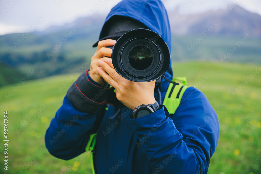 Fototapeta premium Photographer taking photo on grassland mountain top