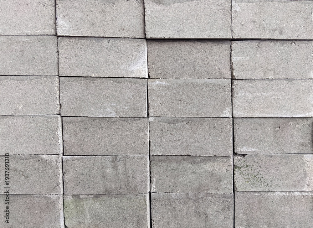 Fototapeta premium ​Neat stack of gray concrete blocks background texture