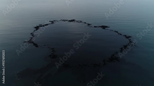 Observing a Circular Dark Ring on Calm Sea Surface in Aerial View
