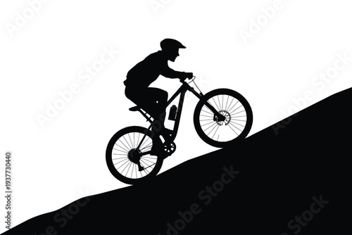 Silhouette of mountain biker riding downhill on a slope