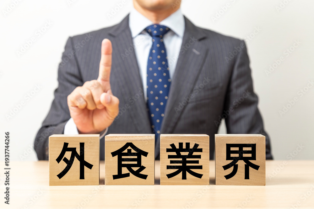 Obraz premium 「外食業界」と書かれたブロックとビジネスマン