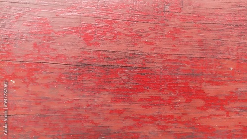 Weathered Red Wooden Surface with Horizontal Grain. Close-up of aged red painted wood with visible scratches and horizontal texture lines