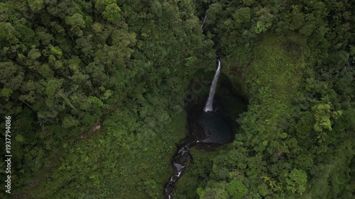 Quebrada Gata aerial tilt up on waterfall on Rio Toro in Costa Rica rainforest in lush green jungle landscape