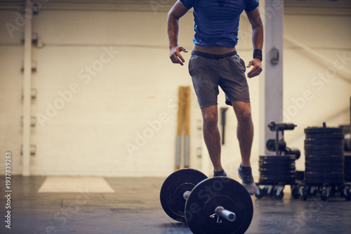 Foto Legs, athlete and jump over barbell at gym for burpees exercise, intense cardio and endurance