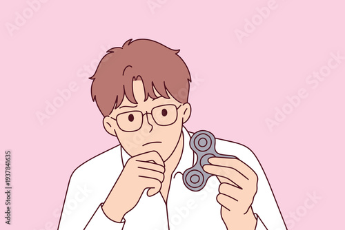Young man with autism using a fidget spinner to manage anxiety and focus his mind while dealing with sensory processing and neurodiversity challenges