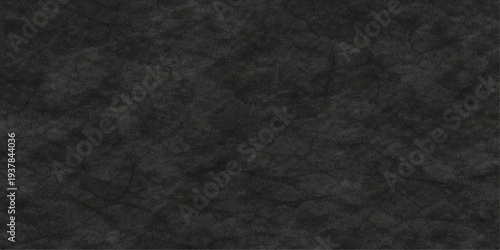 Abstract a moody, dark grey stone texture, perfect for conveying a sense of weight, and depth. This photograph captures the intricate detail and timeless quality of natural stone.