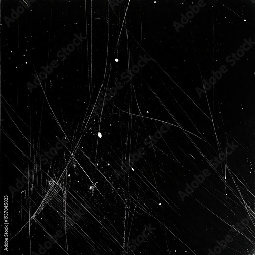 A black background with numerous white scratches and specks scattered