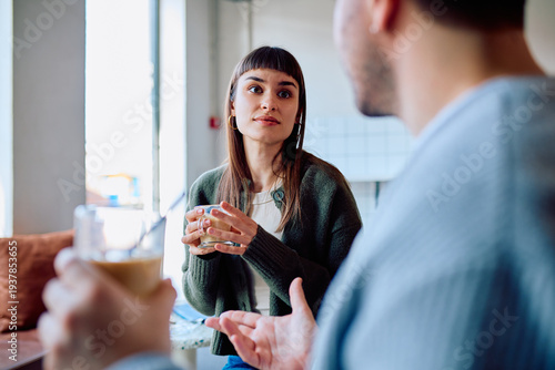 Fotografija Woman and man having a conversation in a coffee shop, engaging in effective comm