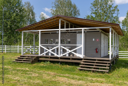 modern camping toilets and shower building on lawn in forest