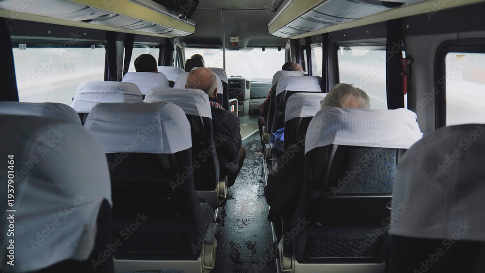 Obraz premium Passengers traveling inside a bus on a road trip with bad weather conditions