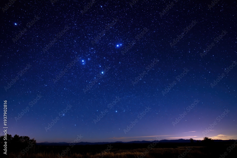 Fototapeta premium Astro nightscape highlighting the Southern Cross in a deep blue sky with distant silhouettes